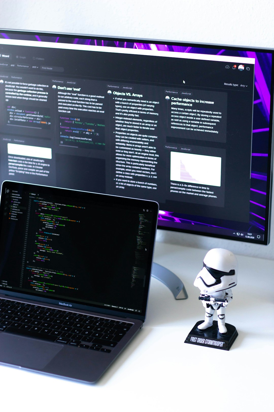 Beautiful and clean white desk with a purple desktop and a space-grey MacBook Air